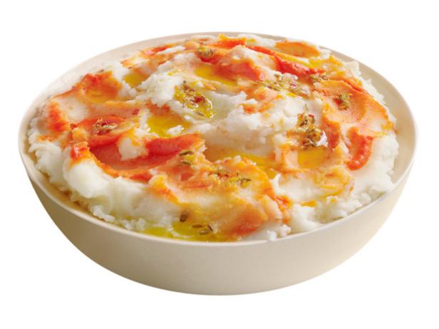 Mashed Potatoes with Seeds and a Red and Yellow Mixture on Top in a Cream Bowl