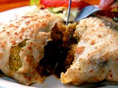 <p>Guy says "they're knocking out the real-deal food from Trinidad" at Pam's Kitchen with dishes like Spicy Jerk Chicken and Pelau. A must-try is the Dahlpuri, an unleavened bread stuffed with yellow split peas, then rolled up and cooked to order on the flattop.</p>