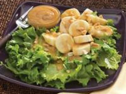 Sliced Bananas on a bed of lettuce with a nut dipping sauce
