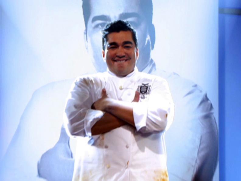 Jose Garces smiling and standing with his arms folded