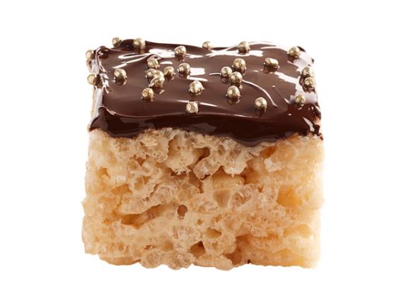 A rice treat covered with chocolate and topped small metalic balls