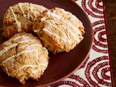 Biscuit Shaped Pastry Drizzled with Frosting on a White and Burgundy Place Mat