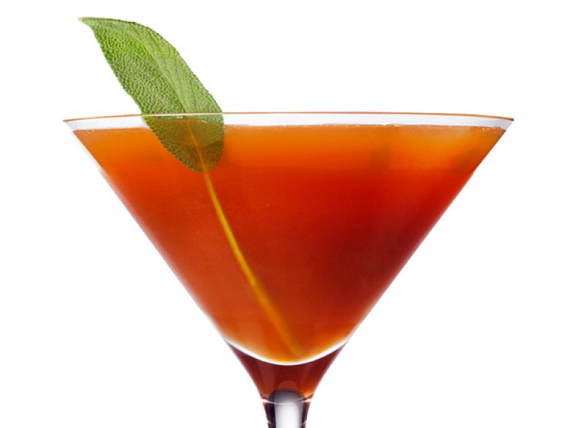 A Red Orange Cocktail with a Piece of Sage Sticking out of it