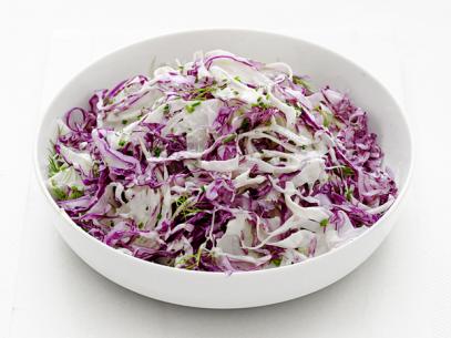 Slaw garnished with herbs in a white bowl