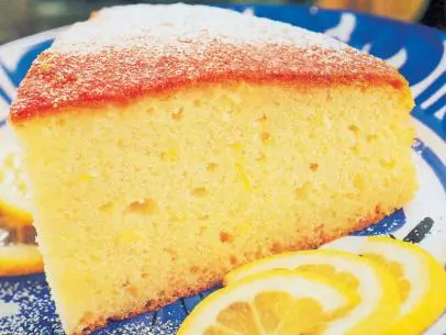 Lemon Cake beside Lemon Slices on a Blue and White Plate