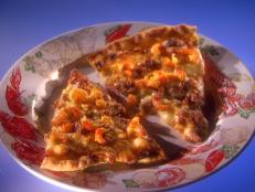 Andouille Sausage Pizza on a white dish with a crawfish and vegetable print