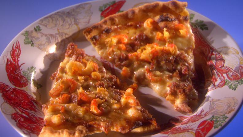 Andouille Sausage Pizza on a white dish with a crawfish and vegetable print