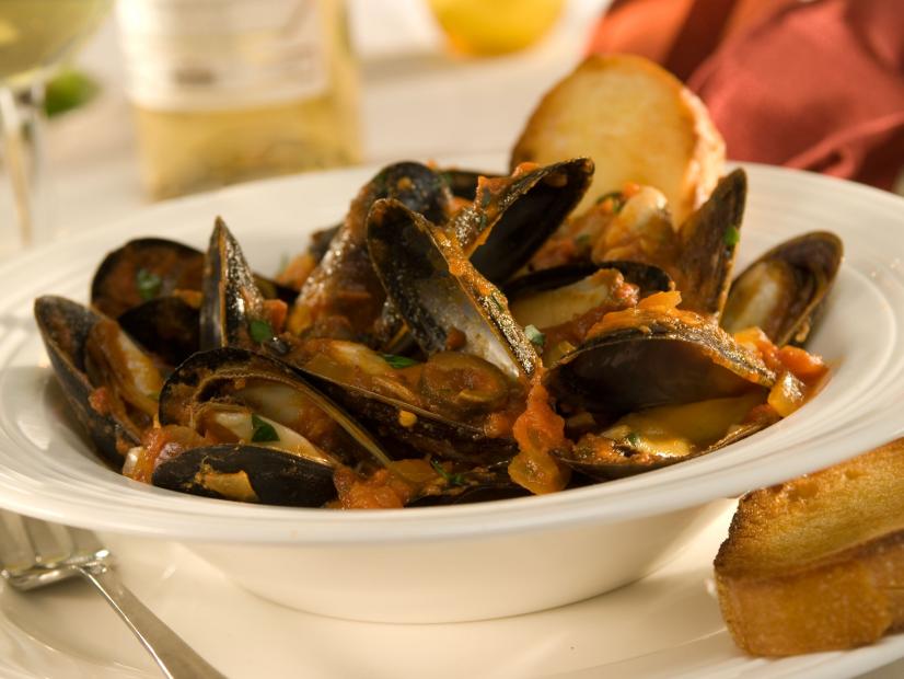 Mediterranean Mussels with bread in a plain white dish