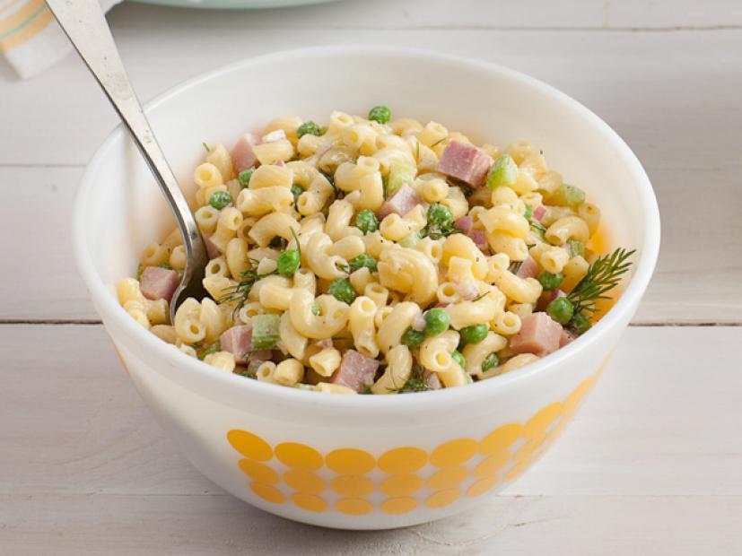 Macaroni salad with diced ham in a white bowl with yellow dots