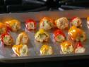 Stuffed red and yellow peppers placed on a baking sheet