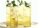 Four glasses of apple mint punch are served with a fresh mint garnish.