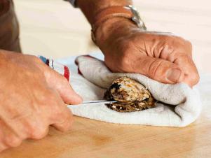 Hold Oyster In Palm Of Hand With Towel To Shuck