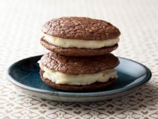 Alex makes dark chocolate whoopie pies that are laced with lemon zest and spreads between them a rich cream, made with egg yolks and almond-infused milk.