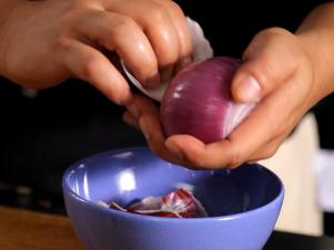 Peeling Purple Onion Into Blue Bowl