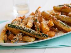 To make the most delicious zucchini fries, Giada breads the strips in crunchy Panko and Parmesan before frying to golden-brown perfection.