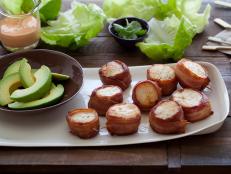 Tyler Florence serves his bacon wrapped scallops with a spicy sauce made of mayo, Sriracha and a little bit of lime juice. Tyler suggests using the biggest scallops you can find, then wrap in thin-sliced bacon and cook under the broiler for this fan-favorite simple appetizer.