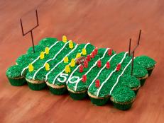 Assemble individual cupcakes to create a football field complete with icing yard lines and cookie goalposts from Food Network.