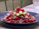 A cucumber tomato salad is served.