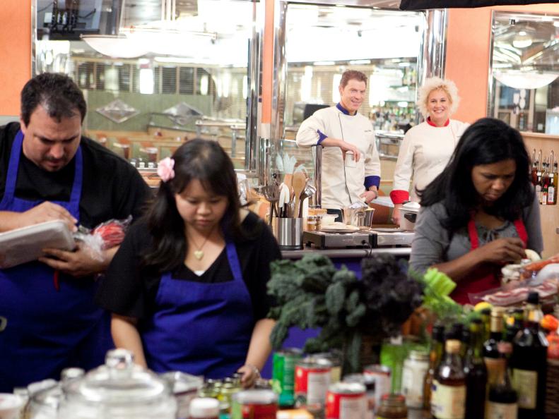 Chef Bobby Flay and Chef Anne Burrell watch as the Red and Blue teams attack their challenges of Late Night Fries and Late NIght Nachos respectively, as seen on Food Network’s Worst Cooks in America, Season 3.