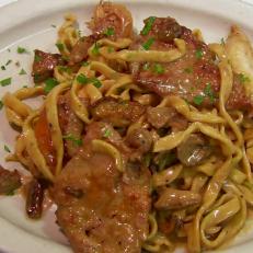 Veal and chicken pasta is served with mushrooms and parsley.