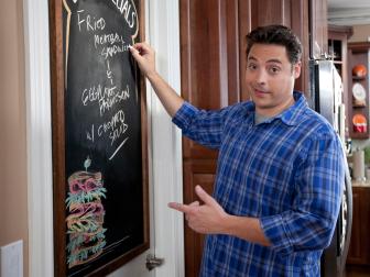 Jeff Mauro cooking in his kitchen as seen on Food Network’s Sandwich King, Season 2.