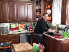 Jeff Mauro cooking in his kitchen as seen on Food Network’s Sandwich King, Season 2.