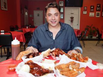Host Jeff Mauro is having the BBQ feast at Honey-1 BBQ with plates of Rib tips, smoked chicken, hot links and perch, served with the homemade BBQ sauce, as seen on Food Network's $24 in 24, Season 1. 