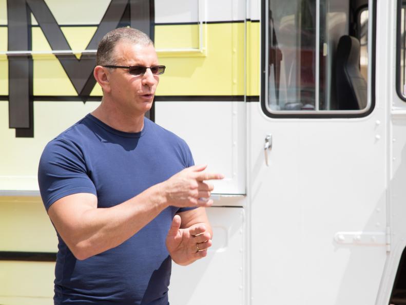 Host Robert Irvine introduces the food truck challenge to contestants at Fashion Island in Newport Beach, CA as seen on Food Network's Restaurant Express, Season 1.