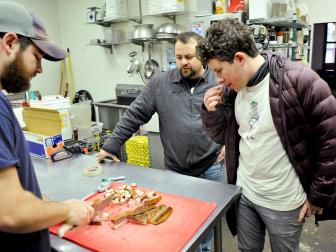 Host Justin Warner helps prepare a smoked pig at Pisgah Brewing with Micheal Moore of Blind Pig, as seen on Food Network's Rebel Eats Special.