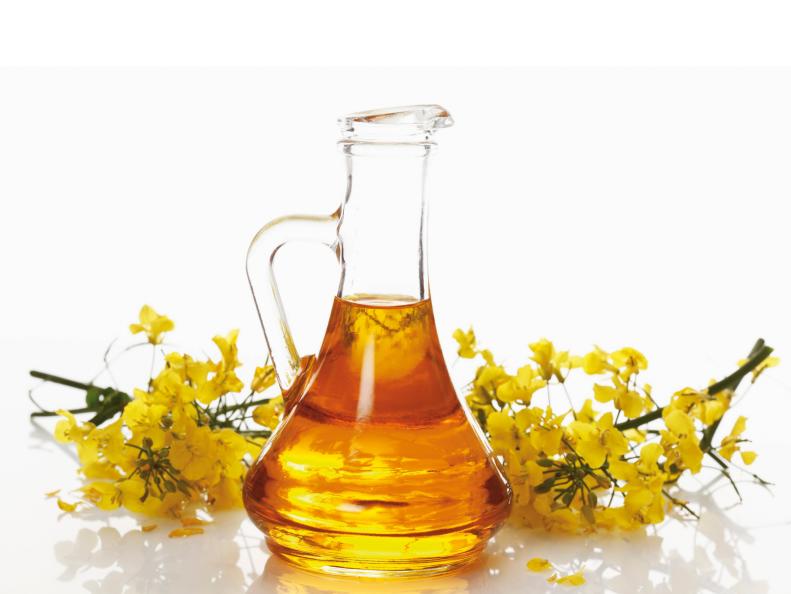 Bottle of fresh canola oil with rapeseed flowers