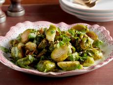 Food Network Kitchen's Roasted Garlic Brussels Sprouts crisp up in the oven with cumin, lemon, brown sugar and garlic.