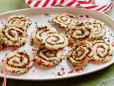 Jeff Mauro rolls cherries and pistachios into his dough before covering the cookie logs with sprinkles. Slice and bake the pinwheels after a night in the fridge.