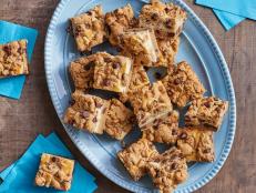 Cheesecake filling is tucked between two layers of chocolate chip cookie in these chocolate chip cheesecake bars from Trisha Yearwood, as seen on Food Network.