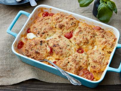 FNK TOMATO COBBLER WITH PARMESANBASIL BISCUITS, Food Network Kitchen, Food Network, Olive Oil, Onion, Garlic, Basil, Red Pepper, Tomatoes, Cherry or Grape Tomatoes, Allpurpose Flour, Mini Mozzarella Balls, Yellow Cornmeal, Baking Powder, Sugar, Unsalted Butter, Buttermilk, Parmesan