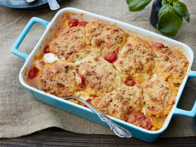 FNK TOMATO COBBLER WITH PARMESANBASIL BISCUITS, Food Network Kitchen, Food Network, Olive Oil, Onion, Garlic, Basil, Red Pepper, Tomatoes, Cherry or Grape Tomatoes, Allpurpose Flour, Mini Mozzarella Balls, Yellow Cornmeal, Baking Powder, Sugar, Unsalted Butter, Buttermilk, Parmesan