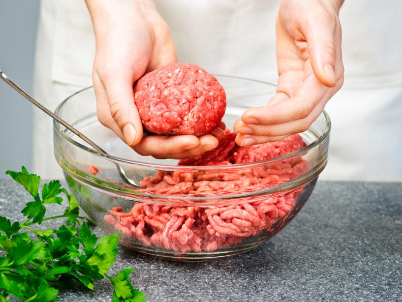 Chef making hamburgers in kitchen with ground beef