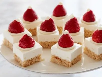 Key Words: Santa Hat CrispyTreat Cheesecake Squares, Cheesecake, Mini Marshmallows, Honey, Vanilla Extract, Crispy Rice Cereal, Gelatin, Cream Cheese, Sour Cream, Confectioner’s Sugar, Lemon Juice, Strawberries, Butter