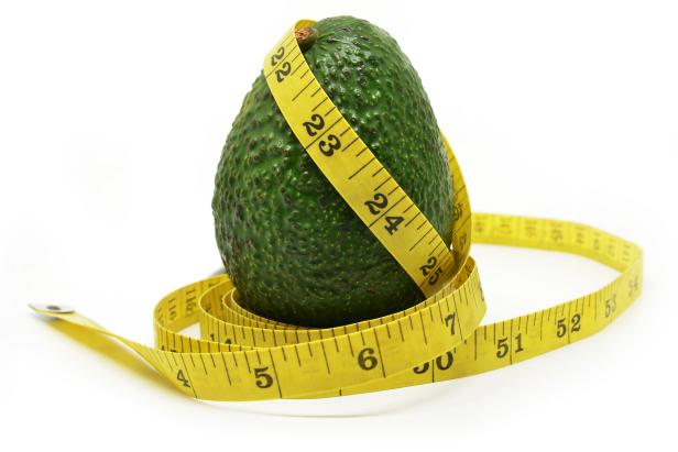 831652212 Avocado with measuring tape isolated on white