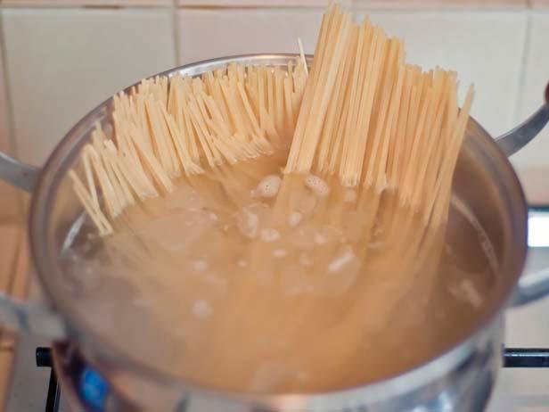 Spaghetti cooking in large pot of salted, boiling water.