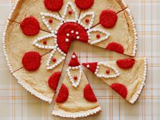 This holiday decorating project is a delicious brain teaser. "Where is the Santa?" you'll ask yourself as you pipe decorative circles and triangles over the giant sugar cookie. But then, you will suddenly see them — eight Kris Kringles! Separate the cookie into wedges for serving, or present the entire cookie and let your guests find Santa for themselves.