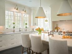 White Eat-In Kitchen With Large Island and Pendant Lights