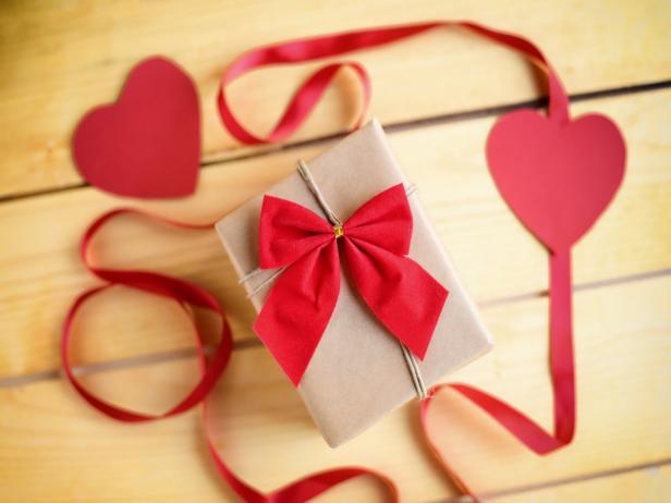636292710 Gift box with a red heart on wooden background