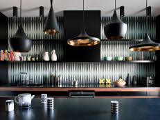 This sleek, black kitchen is a perfectly elegant, stylish and functional Midcentury Modern space. The space has plenty of functional elements, for example the kitchen island and open shelving, whose clean lines contribute to the Midcentury Modern design of the space, while elements such as the gold-lined pendant lights help to add glamour and pizzaz.