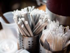 Plastic straws wrapped in paper and plastic forks are seen at a food hall in Washington DC on June 20, 2019. - "How do you drink a milkshake without a straw?" The city of Washington has decided, in the name of the environment, to ban plastic drinking straws -- an act viewed as almost sacrilegious in the birthplace of this simple but seemingly indispensable part of daily American life.In the last century, millions of straws were produced in the Stone Straw Building, a stolid-looking structure of yellowing brick in a residential neighborhood. The building now houses the capital's transit police headquarters. The only visible sign of its historic character comes from a discreet commemorative plaque affixed to a wall above a garbage bin that honors the memory of Marvin C. Stone, "Inventor of the Paper Straw." (Photo by Eric BARADAT / AFP)        (Photo credit should read ERIC BARADAT/AFP/Getty Images)