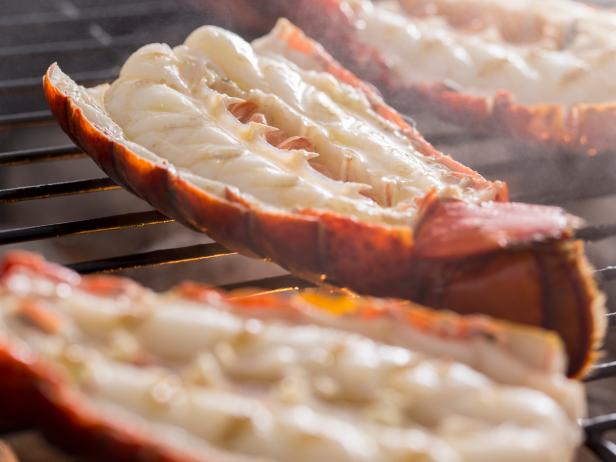 Fresh cold water lobster tails being cooked on a outdoor grill.