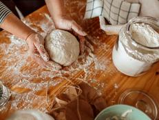 Close-up of woman's hands kneading sourdough on the table
