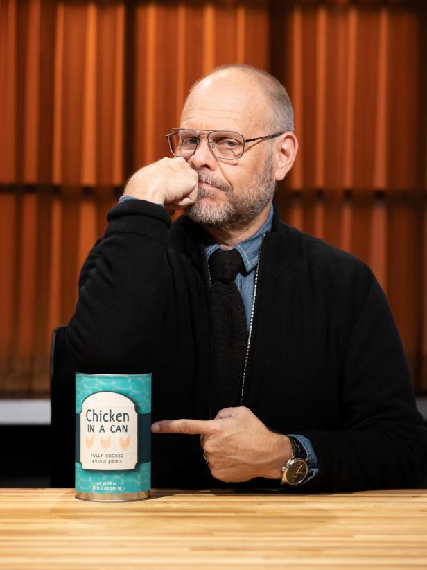 Judge Alton Brown with fan choice round 1 basket ingredient chicken in a can, as seen on Chopped, Season 50, Alton Brown Maniacal Baskets Tournament.