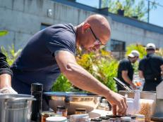 Chef Michael Symon with chef Katie Pickens and competitors Eli Sussman and Max Sussman race to finish their chicken shawarma dish, as seen on Throwdown with Michael Symon, Season 1.