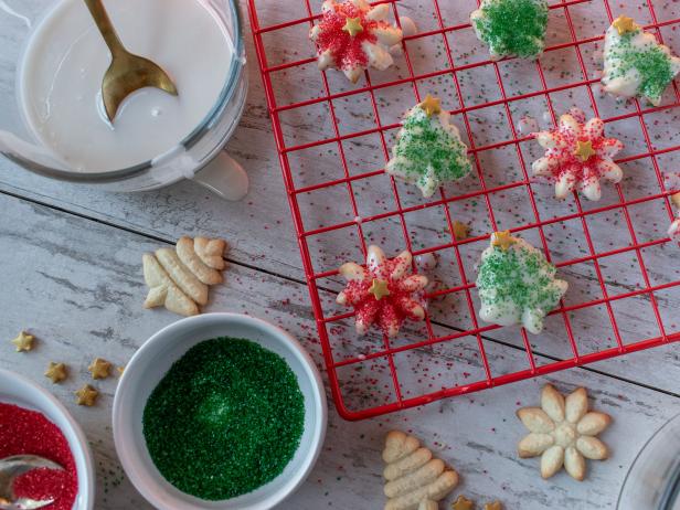 Homemade Royal icing Christmas sugar cookies with sprinkles on drying rack flat lay