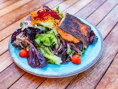 Blackened Salmon and green salad on blue plate